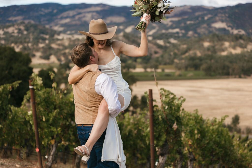 Groom lifts his bride high into the air in Sonoma County