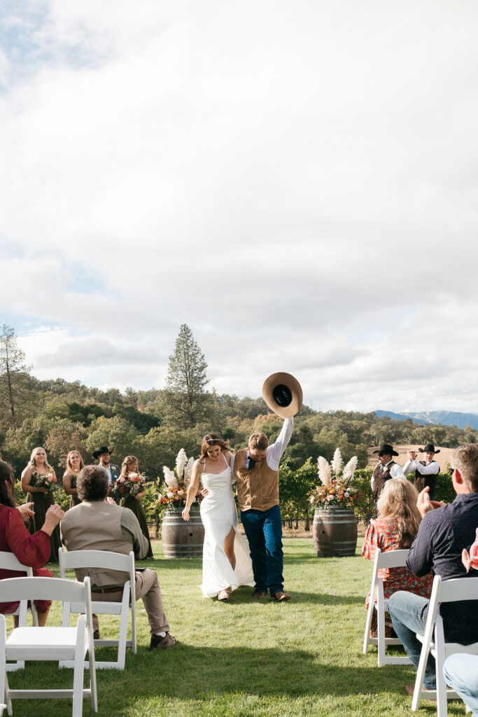 A cowboy hat toast from the groom as he walks down the isle