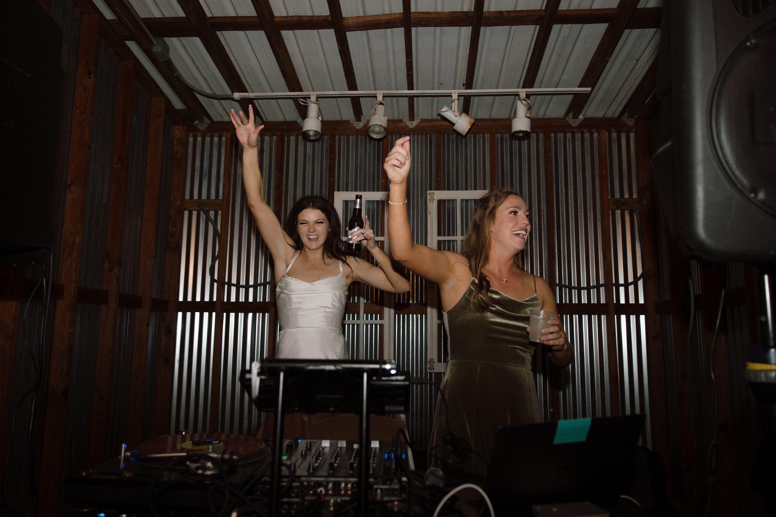 Bride and bridesmaid partying at the dj booth