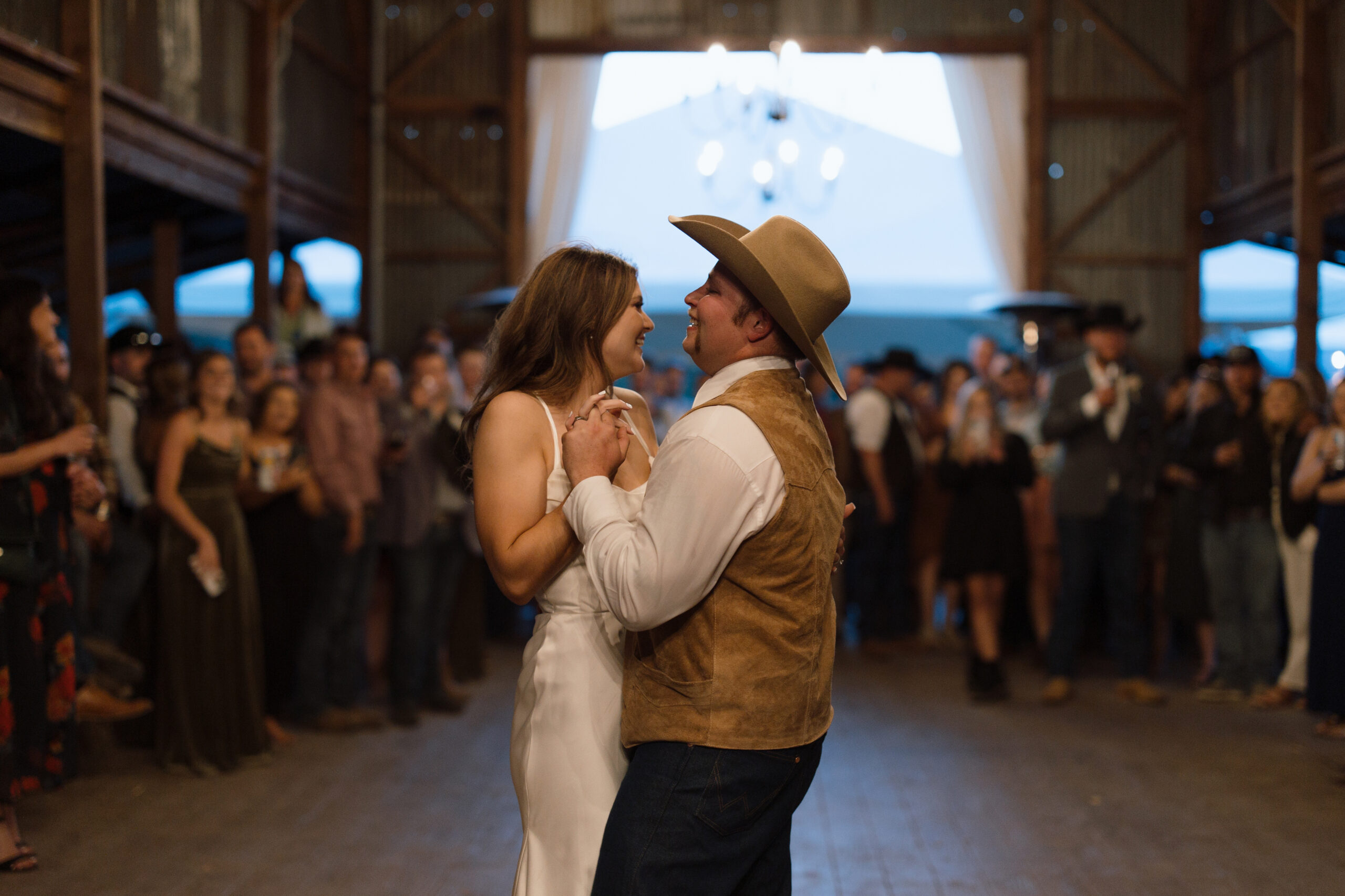 Bride and groom first dance in barn, with flash photography